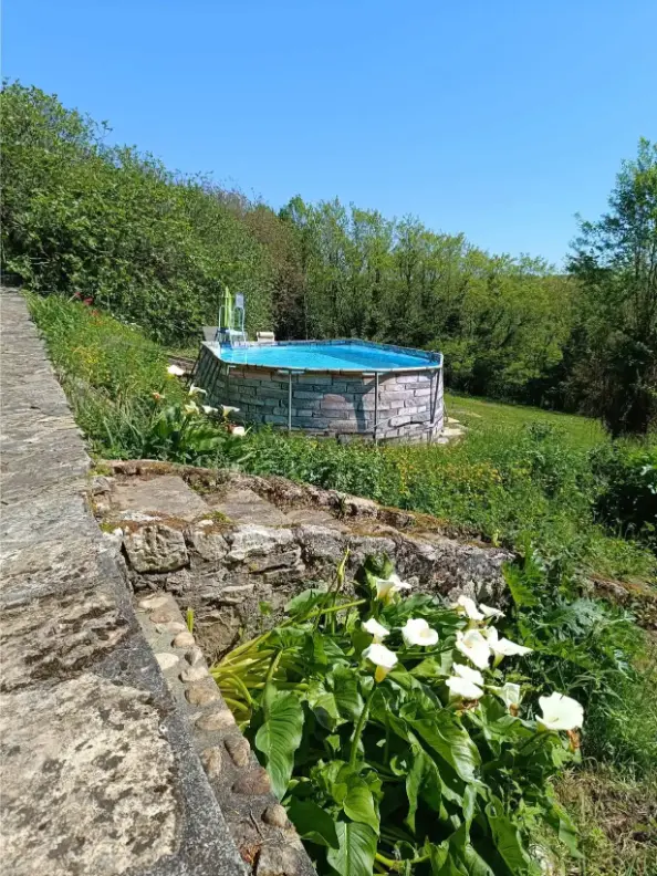 Deux ânes vus en gros plan à l'intérieur de leur abri, l'un sombre aux grandes oreilles regardant directement l'objectif, l'autre brun en arrière-plan, sur de la paille, La Fontaine du Mas